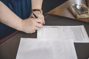 Client signing legal documents at a desk during a mobile notary appointment in Bangkok