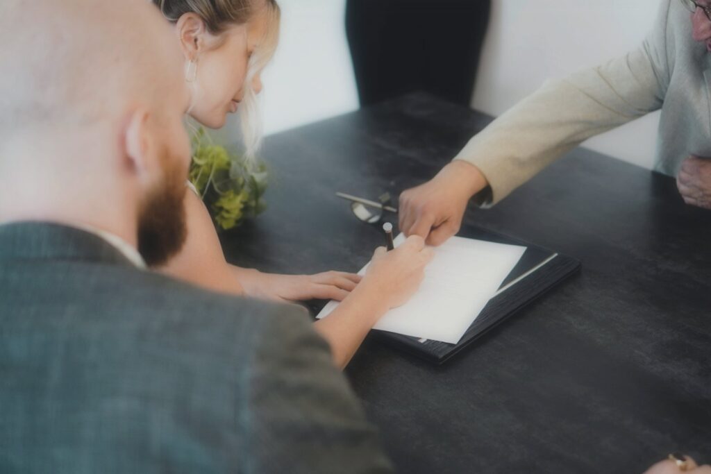 Client signing a document in front of a notarial services attorney after showing proof of identity